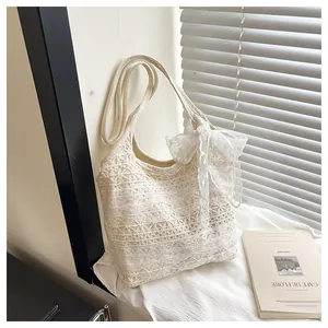 Nahaufnahme der cremefarbenen Spitzen-Tote-Bag mit floralem Muster und großer Schleife