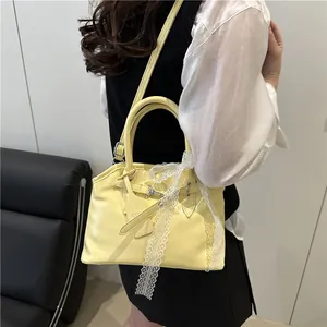 Détail d'un sac à main jaune pâle avec dentelle délicate et bandoulière réglable