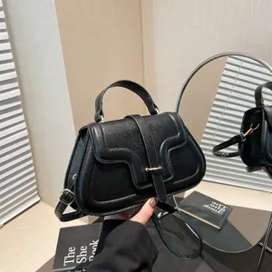 Fashionable black pebbled leather handbag with gold U-shaped buckle and top handle