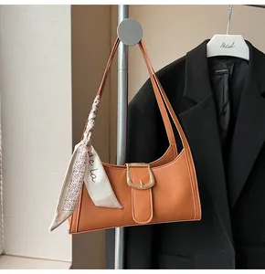 Dettaglio borsa trama coccodrillo con fibbia dorata e foulard decorativo in seta