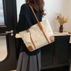 Large vintage print tote bag set in cream and brown, styled on a model in home setting