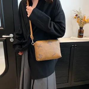Brown vintage tote bag with blue letter print and adjustable strap in modern room
