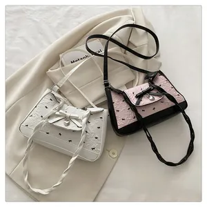 Détail des nœuds et pendentifs cœur sur des sacs à bandoulière plissés pour femmes