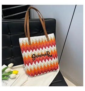 Dettaglio ricamo Summer su borsa tote intrecciata colorata con motivo a onde e manici in pelle