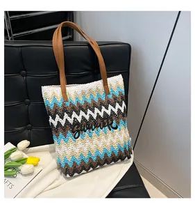 Dettaglio della borsa Summer con motivo a onde colorate e manici in pelle marrone