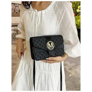 Minimalist black crossbody bag with grey M-pattern and gold circular logo buckle for women