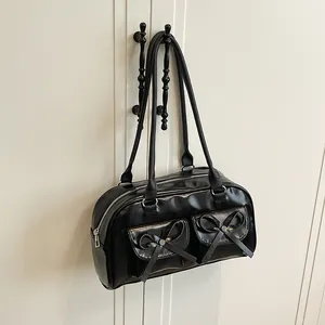 Black glossy shoulder bag with bow accents and dual pockets in a balletcore style