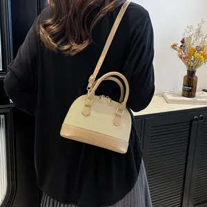 Elegante bolso de lona beige y cuero usado por una modelo en un interior minimalista