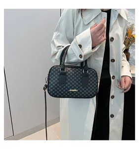 Sac Boston noir avec motifs géométriques et détails dorés porté par un mannequin