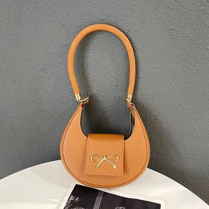 Sac bandoulière demi-lune marron minimaliste avec boucle dorée en nœud et anse élégante