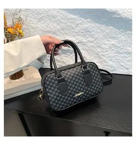Détail du sac Boston montrant les ferrures dorées et le motif géométrique gris chic