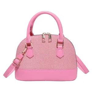 Pink woven shell-shaped crossbody bag with faux leather handles and gold-tone hardware