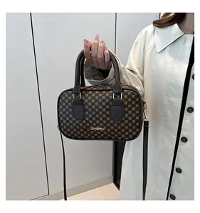 Vue détaillée du sac Boston vintage avec motif logo, ferrures dorées et bandoulière cuir