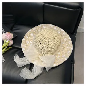 Straw sun hat with white mesh bow and floral embroidery details in light beige