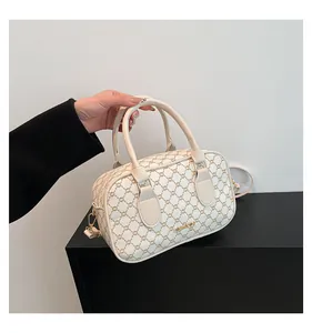 Gros plan détaillé d'un sac Boston avec motif vintage et garniture métallique dorée