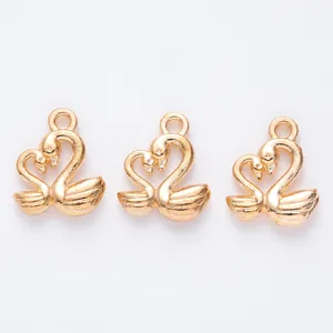 Détails macro des pendentifs cygnes dorés en forme de cœur pour bijoux DIY artisanat