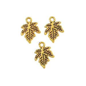 Detailed macro of three gold-plated maple leaf charms for DIY jewelry making and crafts