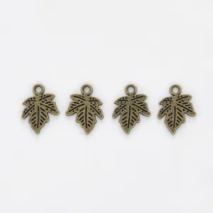 Macro view of four antique bronze maple leaf alloy charms with detailed vein texture