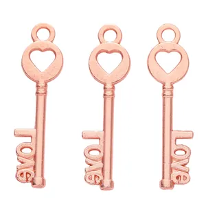 Detailed macro view of three rose gold alloy key pendants with heart and love engravings