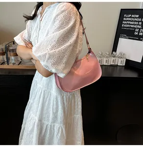 Borsa sottobraccio in pelle verniciata rosa portata da modella in abito di pizzo