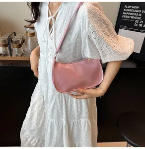 Dettaglio della borsa a spalla in pelle verniciata rosa con design lucido e finiture dorate