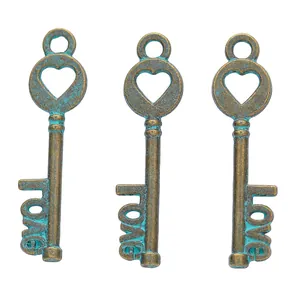 Close-up of three vintage bronze alloy key pendants with heart tops and Love lettering