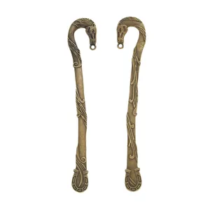 Vintage bronzen bladwijzer met paardenhoofd en hoefijzer detail op witte achtergrond
