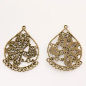 Pair of vintage bronze teardrop charms with intricate peacock design for jewelry making