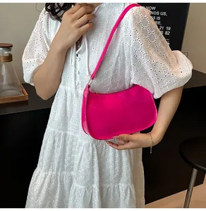 Dettaglio borsa sottobraccio rosa lucido con design a mezzaluna alla moda su modella