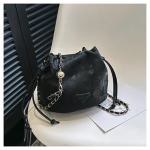 Bolso saco negro de moda en piel vintage con cadena dorada y cierre de cordón ajustable