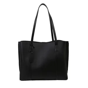 Minimalistische zwarte kunstlederen tote bag met lange banden en fijne kiezeltextuur