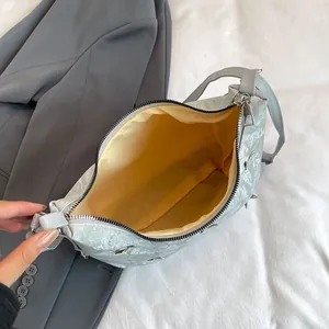 Silver-grey tote bag with metallic texture, spacious yellow interior, and zip closure
