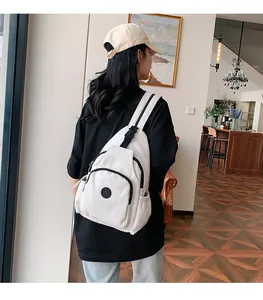 Nahaufnahme der weißen wasserdichten Nylon-Umhängetasche mit Logo an einem Model getragen