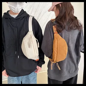 Detail of corduroy crossbody bags in beige and yellow with adjustable straps and zippers