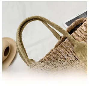 Detailed close-up of tight woven straw texture and reinforced comfortable handle on beach tote