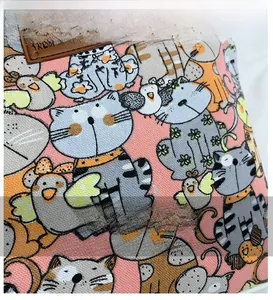 Detail shot of high-quality canvas fabric with hand-drawn cat and bird patterns