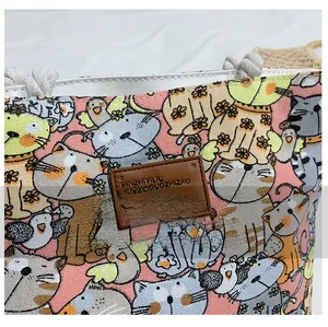 Detail of pink canvas tote with cartoon cat prints and durable rope handle