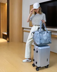 Graue große Reisetasche auf silbernem Koffer für Kurztrips und Yoga Fitness