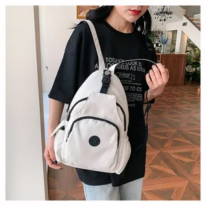 Tragefoto eines weißen Nylon-Rucksacks mit schwarzen Reißverschlüssen im lässigen Stil
