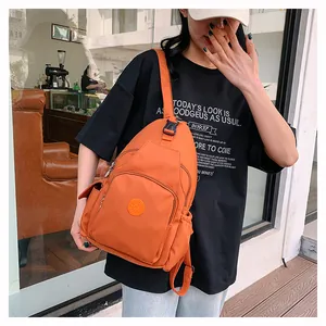 Detailansicht der leuchtend orangefarbenen Nylon-Umhängetasche mit Reißverschlusstaschen