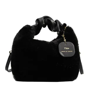 Sac à main chic en fausse fourrure noire avec poignée en cuir plissé et plaque gravée