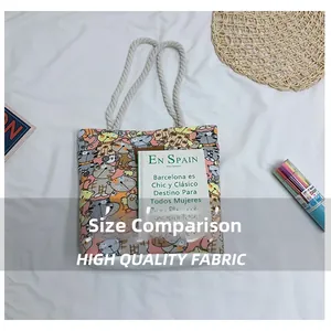 Size comparison of a pink canvas tote bag with cat prints and rope handles showing an A5 book