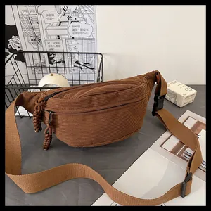 Close-up of brown corduroy waist bag showing striped texture and durable zipper detail