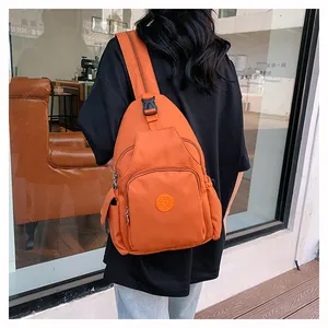 Detailansicht einer hellorangen Crossbody-Tasche aus Nylon mit sportlichem Logo