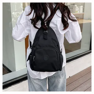 Detail eines schwarzen Nylon-Rucksacks mit Multi-Pocket-Design und Stern-Logo auf weißem Hemd
