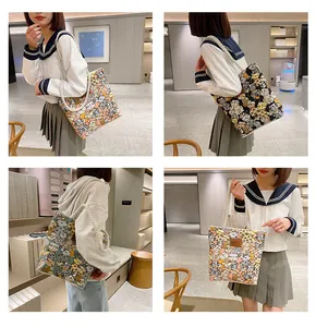Detail of canvas tote bag featuring cartoon cat prints and thick rope handles in multiple colors