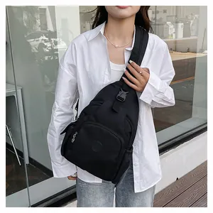 Detail der schwarzen Brusttasche aus Nylon mit Reißverschlussfächern und Schnallen