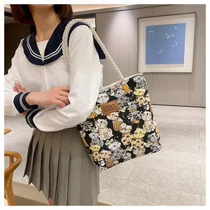Close-up of canvas tote bag featuring cute cartoon cat prints and sturdy rope handles
