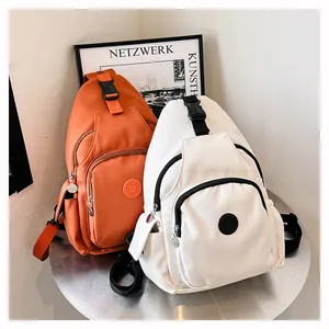 Detail von lässigen Nylon-Umhängetaschen in Orange und Weiß mit SPORT-Logo und verstellbarem Gurt