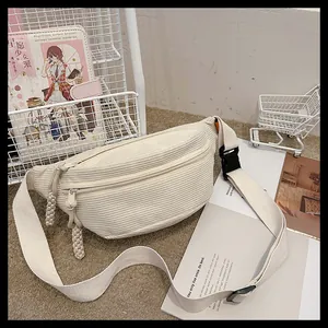Close-up of beige corduroy waist bag showing soft striped texture and canvas strap